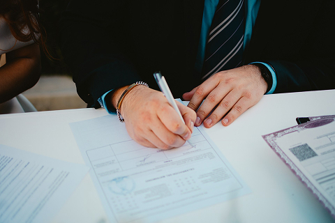 Un hombre firmando unos papeles. Imagen que acompaña al servicio derecho civil