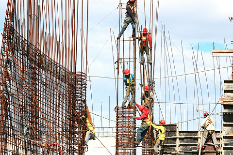 Grupo de obreros montando la estructura de un edificio. Acompaña el servicio de derecho laboral